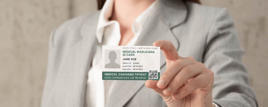 Lady in grey suit holding out a medical cannabis card in natural lighting